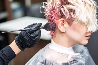 Mujer tiñéndose el pelo en una peluquería, tinte. EP