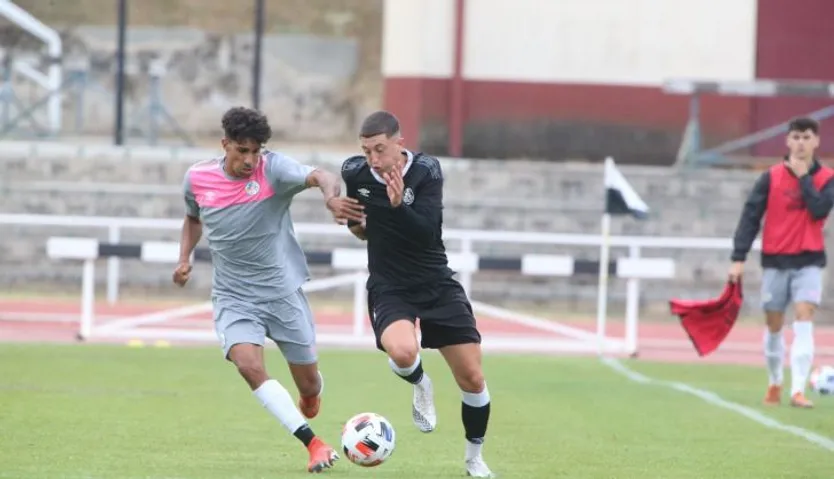 De fondo, un jugador con un peto hace de asistente
