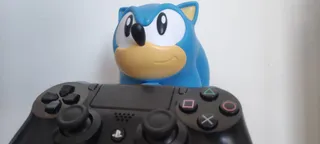 Un muñeco de Sonic (personaje de videojuegos) sostiene un mando de PlayStation 4