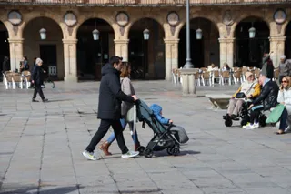 Pareja con carrito de bebé paseando por la Plaza Mayor | Andrea Mateos