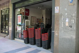 Un comercio coloca una improvisada barrera de cestas para que no entren los clientes al cortarse el suministro eléctrico