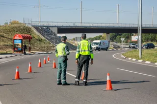 Dos agentes de la Guardia Civil de Tráfico en medio de la carretera durante la campaña especial de la DGT de vigilancia y control de furgonetas, en el Km 0,1 de la M-511, en Madrid, a 28 de octubre