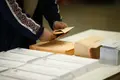 Un hombre mete una papeleta electoral en un sobre
