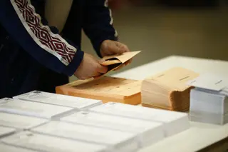 Un hombre mete una papeleta electoral en un sobre
