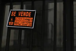 Cartel colgado en un edificio que indica que el inmueble está en venta