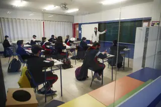 Un profesor imparte clase a los alumnos de un colegio. Foto de archivo