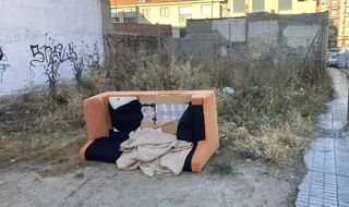 Sofá tirado en el descampado de la calle Flor, en el barrio de Pizarrales