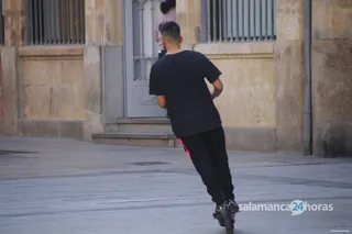 Joven con un patinete eléctrico por Salamanca, imagen de archivo