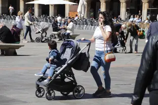 Gente por las calles de Salamanca con carrito de bebé