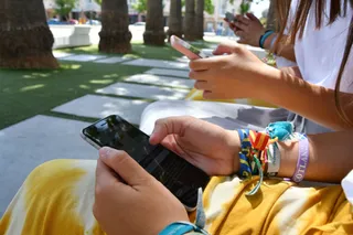 Jóvenes utilizando el movil en un parque. Foto de archivo