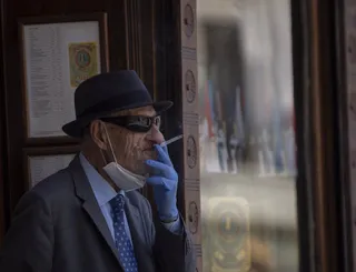 Un hombre fuma con la mascarilla bajada. | EP