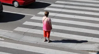 Una mujer espera en un paso de peatones en una calle de Salamanca