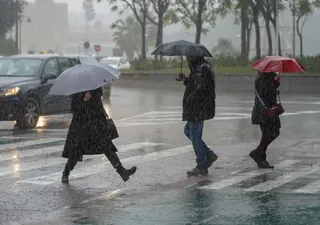 Peatones bajo la lluvia (Imagen de archivo)