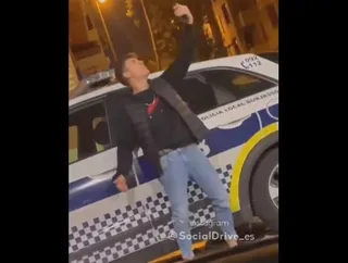 Un joven fotografiándose con un coche de la Policía Local en Valencia. Foto @SocialDrive_es