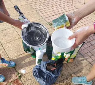 Los vecinos de Los Alcaldes lavando en plena calle a causa del incendio producido en un garaje, en la calle Alcalde Gutiérrez Ceballos.