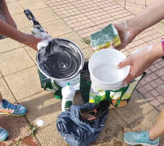 Los vecinos de Los Alcaldes lavando en plena calle a causa del incendio producido en un garaje, en la calle Alcalde Gutiérrez Ceballos.