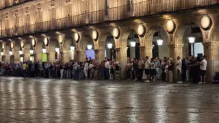 Fans de Tony Hadley se cobijan en los soportales de la Plaza Mayor por la lluvia.