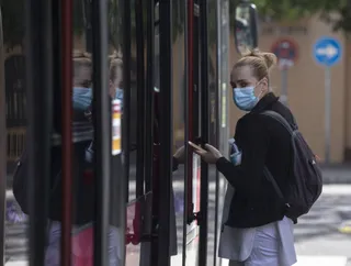 Una pasajera protegida con mascarilla antes de subir a un autobús Tussam. En Sevilla (Andalucía, España), a 04 de mayo de 2020.