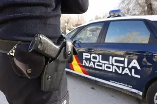 Archivo - Imagen de archivo de un agente y un coche de la Policía Nacional