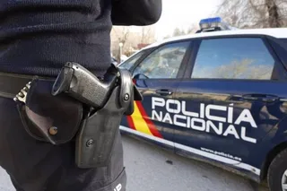 Archivo - Imagen de archivo de un agente y un coche de la Policía Nacional