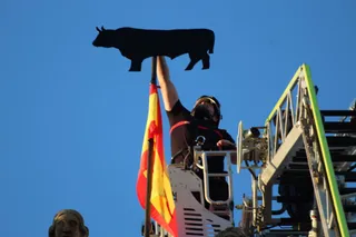 Un bombero coloca La Mariseca en lo alto de la espadaña del Ayuntamiento