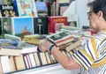 Una persona ojea un libro de segunda mano en una fotografía de archivo de Europapress