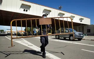 Un agente de Policía Nacional retira la valla en la frontera de Fuentes de Oñoro con Portugal en verano | Foto: ICAL