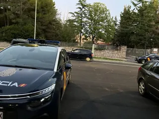 Un policia salta la valla de la antigua residencia San Juan de Dios, frente a la Facultad de Bellas Artes.
