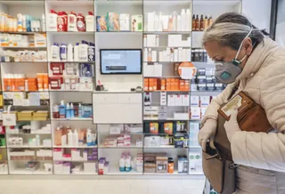 Mujer con mascarilla en una farmacia