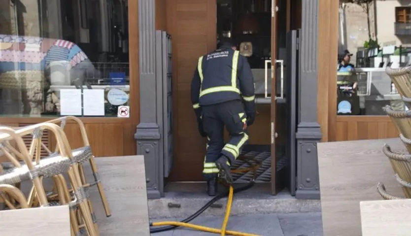 Momento en el que los bomberos sofocan un incendio declarado en un restaurante de la calle Sánchez Barbero durante la mañana de este domingo | Salamanca 24 Horas
