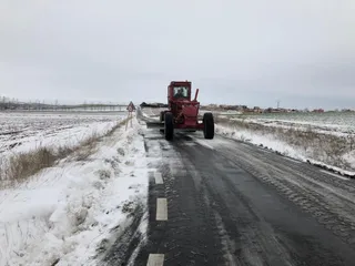 La niveladora quitando nieve en una carretera. Foto de archivo