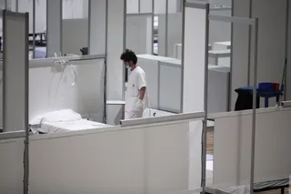 Un profesional sanitario frente a una cama vacía en el interior del hospital de campaña de IFEMA durante su último día de funcionamiento por la bajada de la presión asistencial, en Madrid (Españ