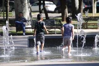 Niños jugando en la fuente del parque Alamedilla para evitar el calor