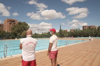 Dos socorristas vigilan la piscina del Polideportivo Vicente del Bosque en Madrid antes de su cierre por adelantado el 1 de septiembre junto al resto de piscinas municipales de la ciudad, una medida