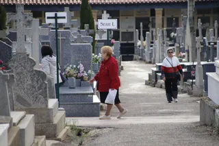Gente visitando a sus familiares en el cementerio