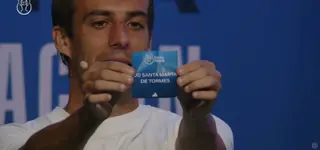 Sergio Santos muestra la papeleta con el nombre de la UD Santa Martas, que actuará como local 