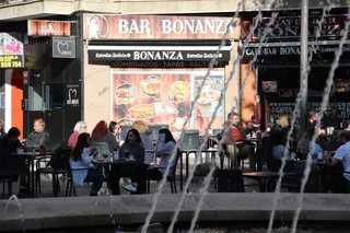 Terraza con gente en la Plaza del Oeste, otoño