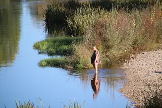Señor bañándose en el río en pleno otoño