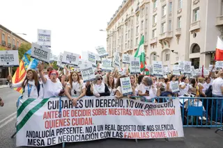 Varias personas durante una concentración por la protección y mejora de la prestación económica CUME, frente al Congreso de los Diputados. EP