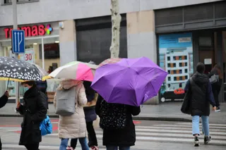 Gente cruza la calle bajo la lluvia