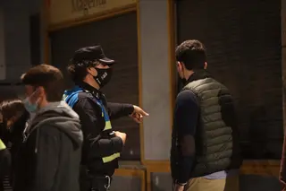 Un policía local de Salamanca habla con un joven.