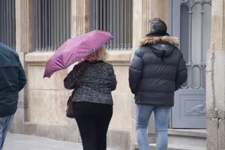 Gente paseando por las calles de Salamanca con paraguas