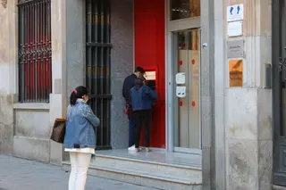Ciudadanos sacan dinero de una entidad bancaria.