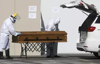 Dos trabajadores con un ataúd