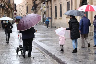 Familia pasea bajo la lluvia | Foto de archivo