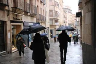 Salmantinos pasean por la calle Toro bajo la lluvia