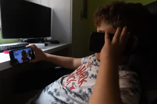Un niño usa el teléfono móvil y una tablet. - Eduardo Parra - Europa Press - Archivo