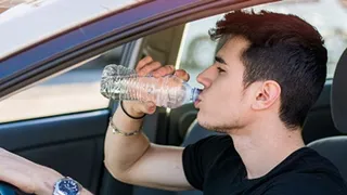Hombre bebiendo agua en el coche | Fotografía Okdiario