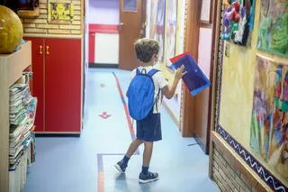 Un niño entrando con su material escolar en el aula | Europa Press