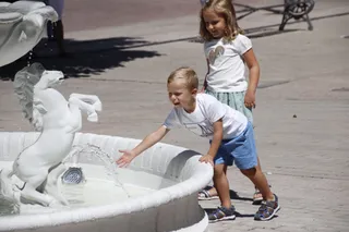 Niños refrescando se en una fuente en verano por el calor